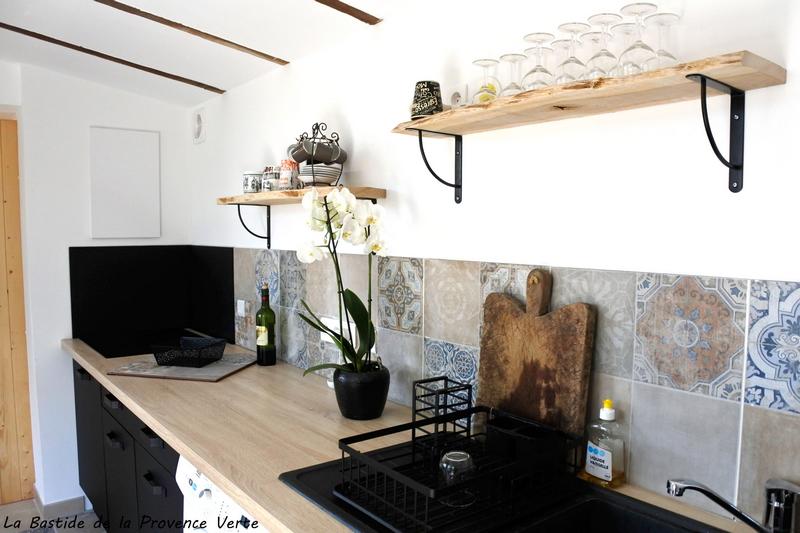 dans notre gîte, vue de l'espace cuisine. Carreaux provençaux au mur, planche à découper, verres à vin, orchidée